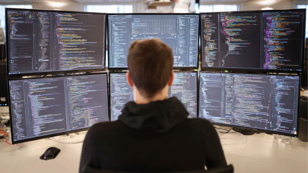 Developer mastering digital leadership skills across multiple screens, navigating modern workplace technology