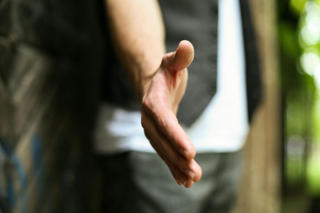 Hand extended toward viewer. A repivot mindset focuses on meaning over optimization