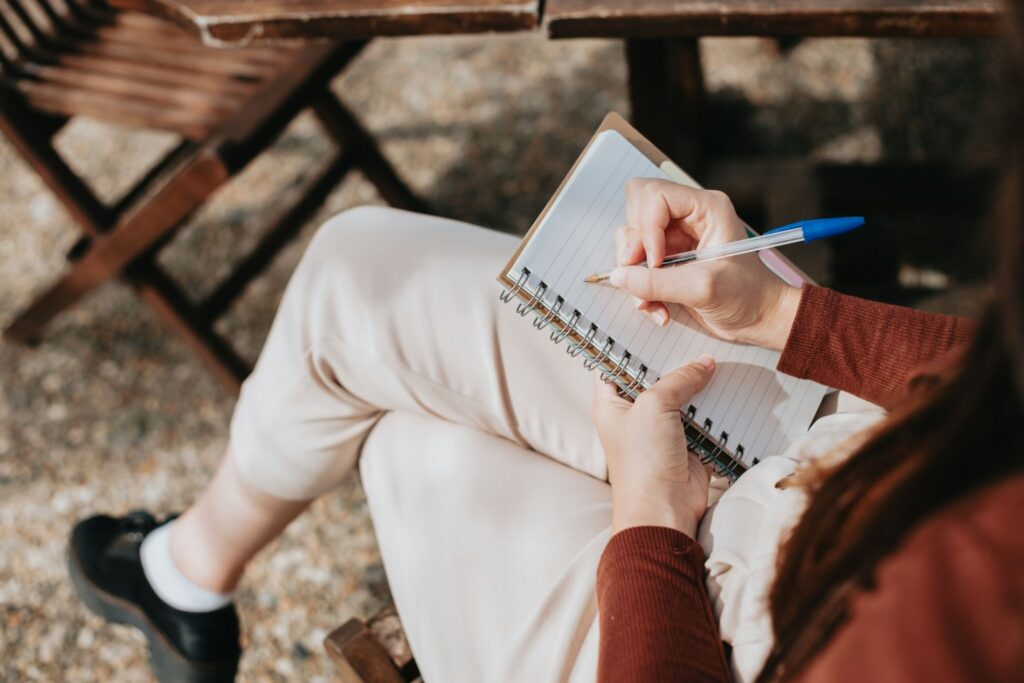 Person writing on a note pad reflecting a repivot mindset: choose what matters, let the rest fade.